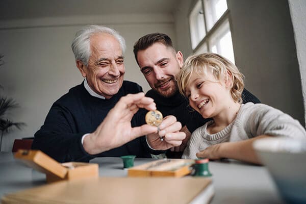 Three generations playing marbles