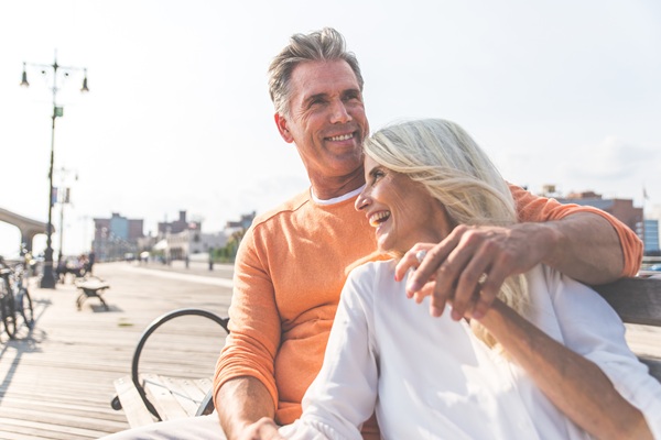 couple laughing together while sitting on a bench